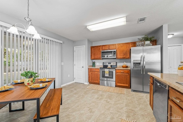 kitchen with an inviting chandelier, light stone countertops, decorative light fixtures, and stainless steel appliances