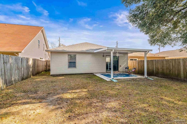 rear view of property with a patio, a yard, and ceiling fan