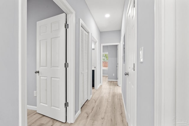 hallway with light wood-style flooring and baseboards