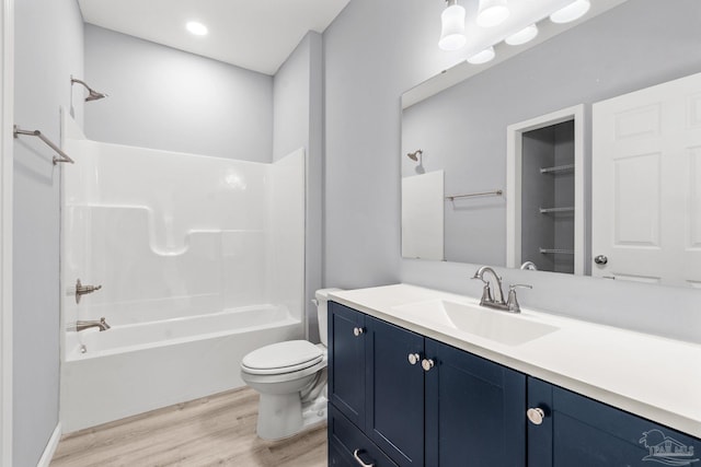 bathroom featuring tub / shower combination, toilet, vanity, and wood finished floors