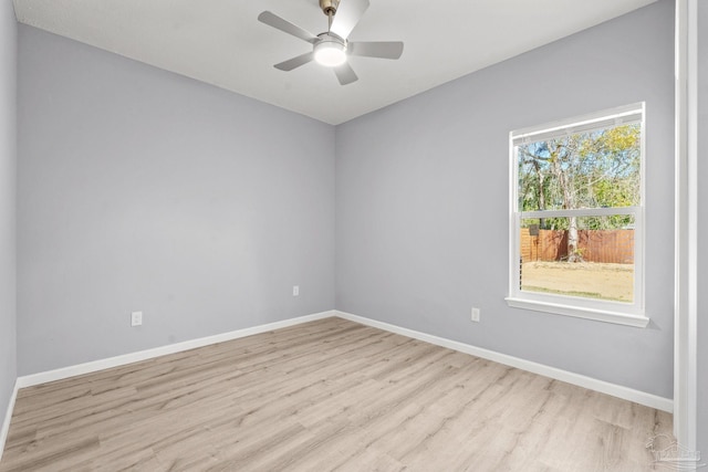 empty room with ceiling fan, light wood-type flooring, and baseboards