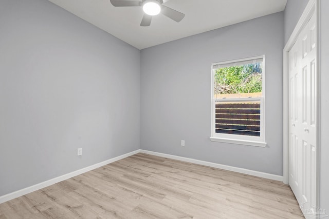 unfurnished room with a ceiling fan, light wood-style floors, and baseboards