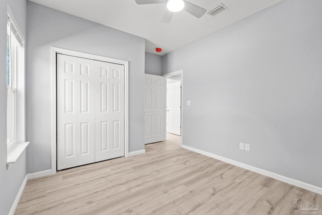 unfurnished bedroom with wood finished floors, visible vents, and baseboards