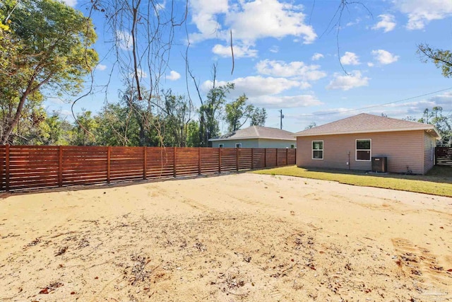 view of yard with central AC unit and fence