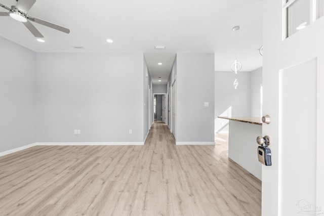 unfurnished room with a ceiling fan, recessed lighting, light wood-style floors, and baseboards