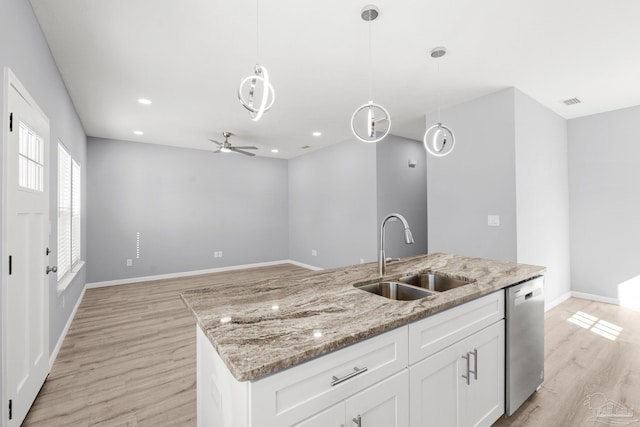 kitchen with stainless steel dishwasher, decorative light fixtures, light wood-type flooring, and a sink