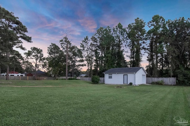 yard at dusk featuring an outdoor structure