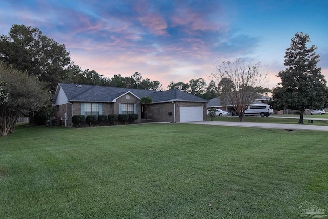 single story home featuring a lawn and a garage