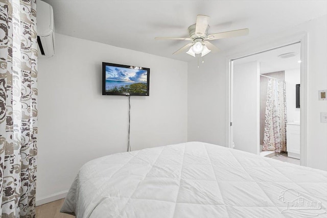 1440 Paradise Point Dr Unit 13, Navarre Beach, FL 32566 - bedroom featuring an AC wall unit, wood finished floors, ceiling fan, and ensuite bathroom