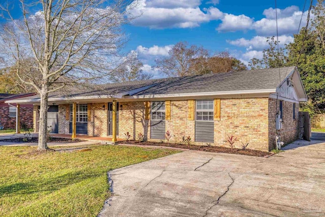 ranch-style house featuring a front yard and brick siding