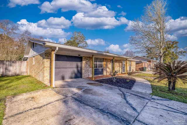 single story home featuring brick siding, concrete driveway, a garage, and fence