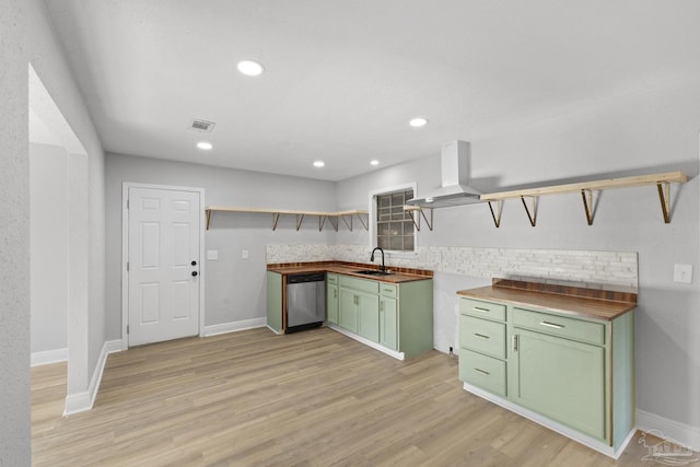 kitchen with green cabinetry, open shelves, a sink, stainless steel dishwasher, and island range hood