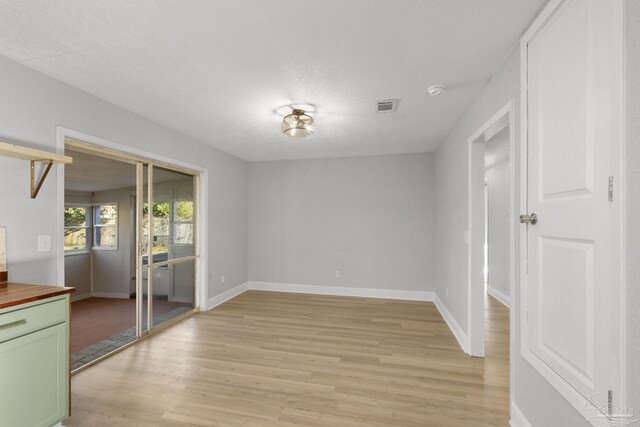 interior space featuring visible vents, light wood-style flooring, and baseboards