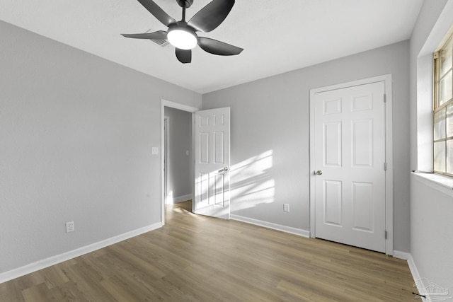 unfurnished bedroom featuring ceiling fan, baseboards, and wood finished floors