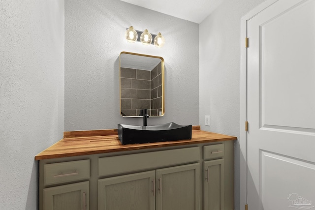 bathroom with vanity and a textured wall