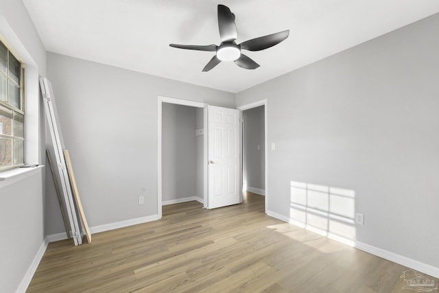 unfurnished bedroom with light wood-style flooring, baseboards, and ceiling fan