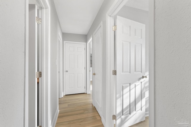 hall featuring baseboards and light wood-style floors