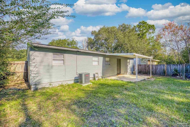 rear view of house with a patio, a yard, and central AC