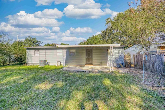 rear view of property featuring a lawn, a patio area, and central AC