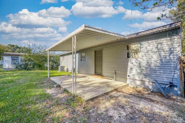 back of property with a lawn, central AC, and a patio