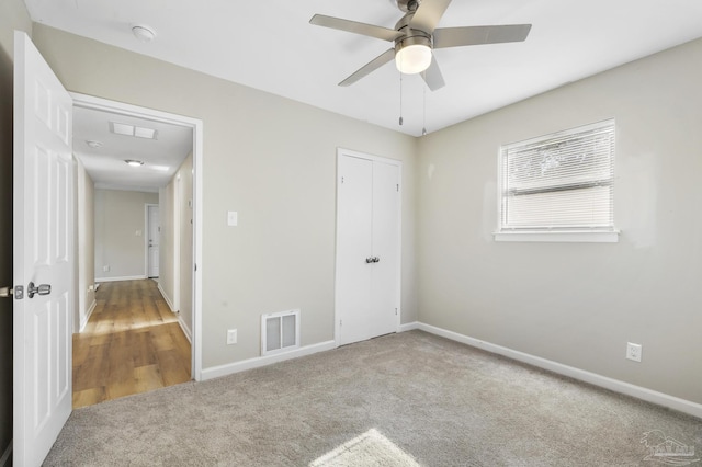 unfurnished bedroom featuring ceiling fan, a closet, and carpet