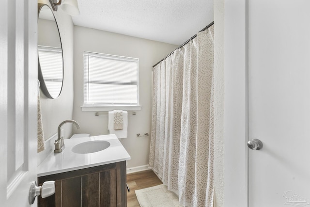 bathroom with vanity, a textured ceiling, and hardwood / wood-style flooring