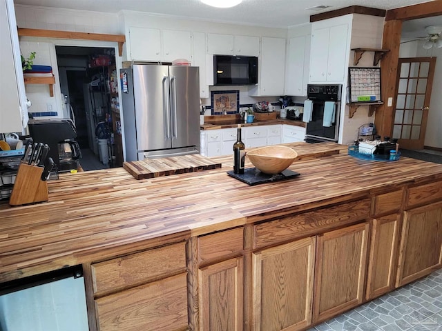 kitchen with white cabinets, crown molding, butcher block counters, and black appliances