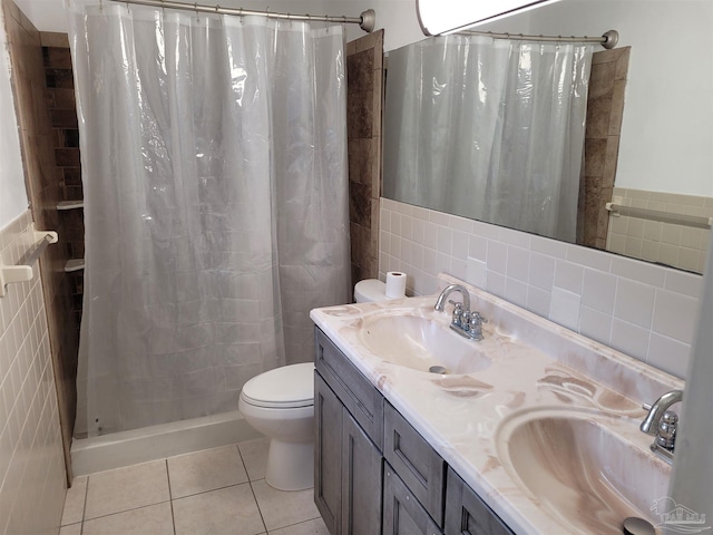 bathroom with tile patterned floors, a shower with curtain, tile walls, and vanity