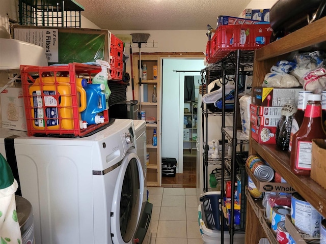 clothes washing area featuring separate washer and dryer, light tile patterned flooring, and a textured ceiling