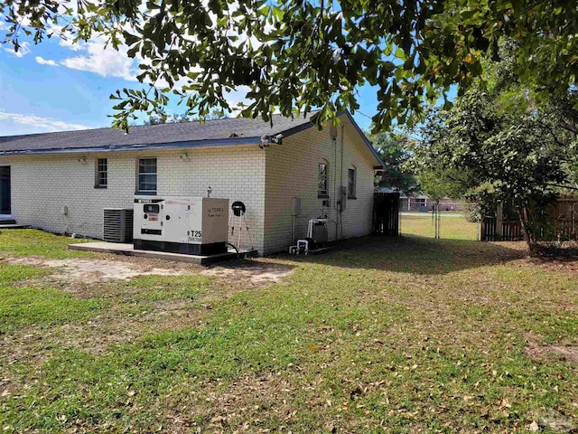 rear view of property featuring central AC and a yard