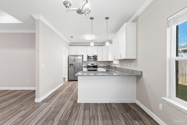 kitchen featuring appliances with stainless steel finishes, hardwood / wood-style flooring, white cabinetry, and sink