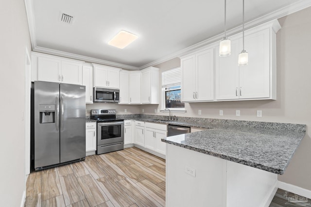 kitchen with pendant lighting, white cabinets, light hardwood / wood-style floors, kitchen peninsula, and stainless steel appliances