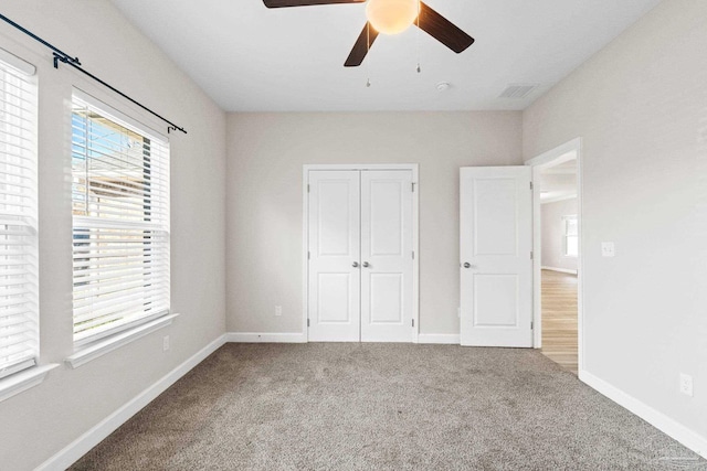 unfurnished bedroom featuring ceiling fan, a closet, and carpet