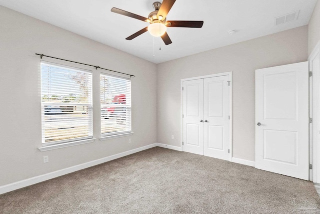 unfurnished bedroom featuring carpet, ceiling fan, and a closet