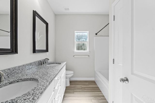 full bathroom with shower / bathing tub combination, vanity, hardwood / wood-style flooring, and toilet