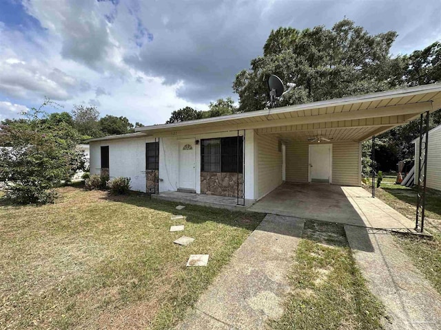 ranch-style home featuring a front lawn and a carport