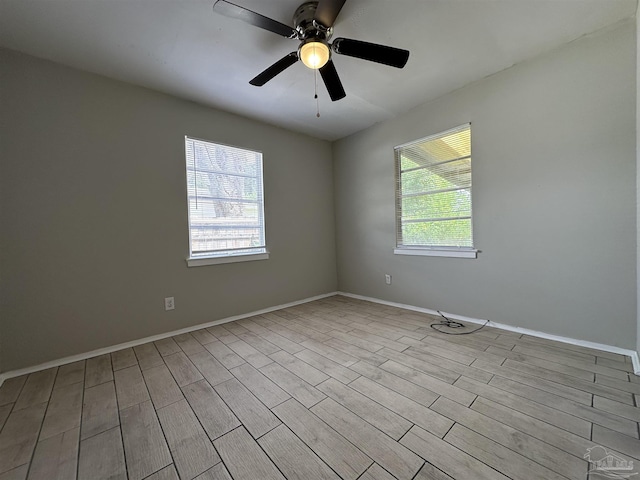 empty room with ceiling fan and light hardwood / wood-style flooring