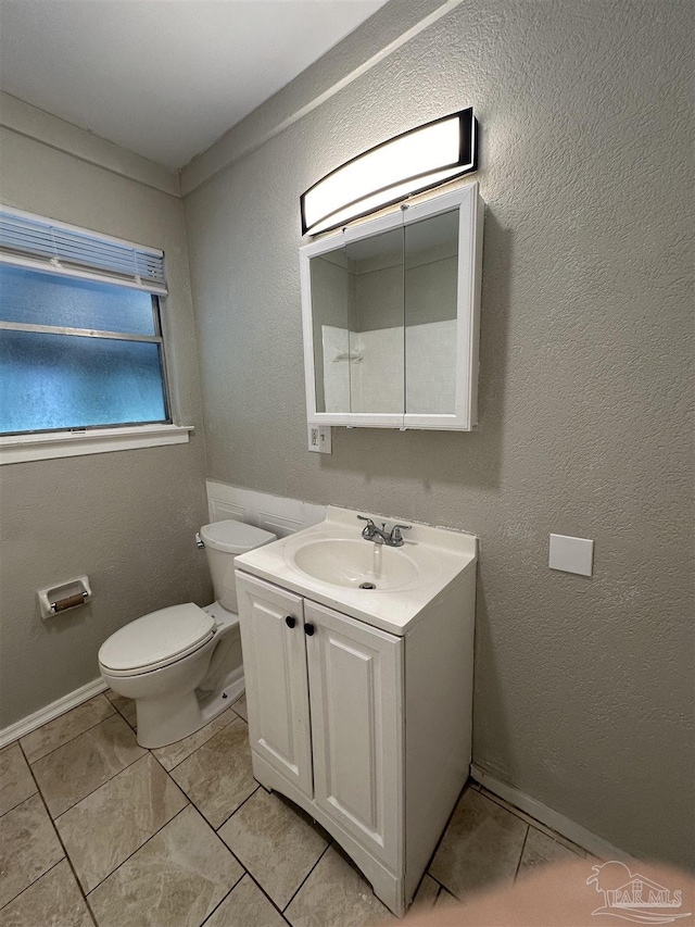 bathroom featuring vanity, tile patterned flooring, and toilet