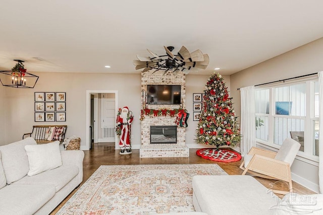 living room featuring a stone fireplace and a chandelier