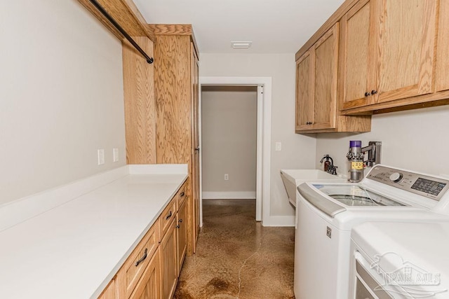 laundry room with washing machine and dryer, sink, and cabinets