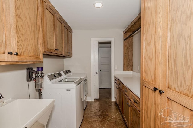 washroom with separate washer and dryer, sink, and cabinets