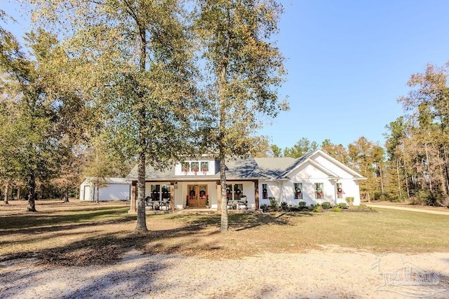 view of front of home with an outbuilding, a front lawn, a porch, and a garage