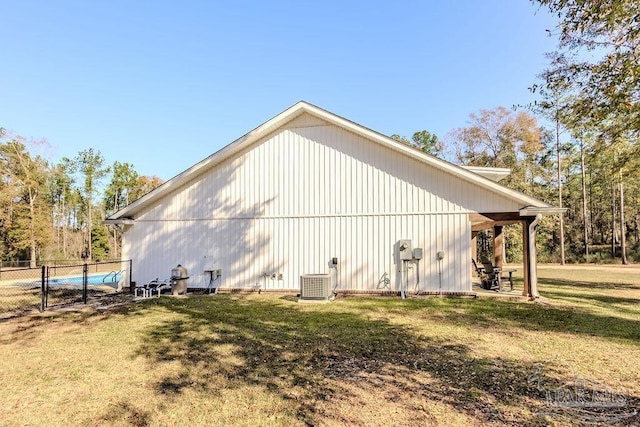 view of side of property featuring central air condition unit and a lawn