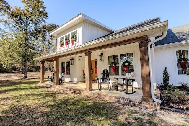 rear view of property with a yard and covered porch