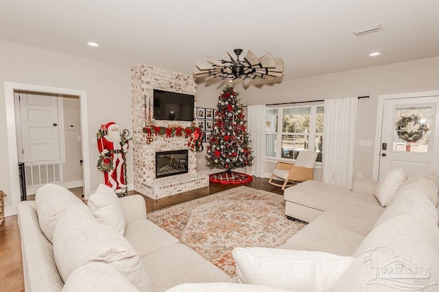 living room featuring hardwood / wood-style flooring and a brick fireplace