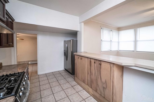 kitchen with light tile patterned floors, stainless steel appliances, and a baseboard radiator