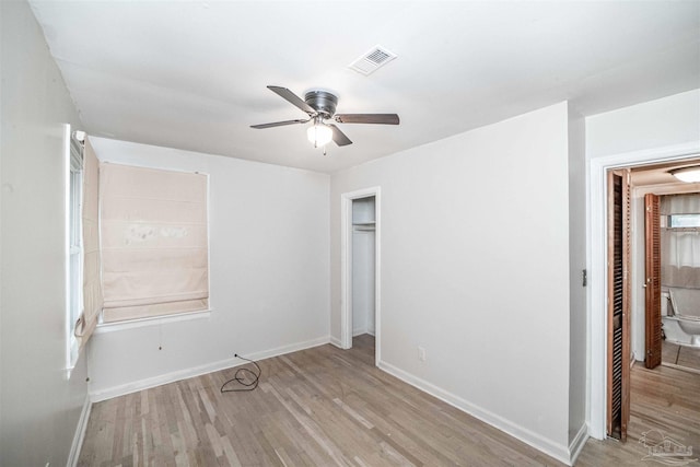 unfurnished bedroom featuring ceiling fan, connected bathroom, and light hardwood / wood-style flooring