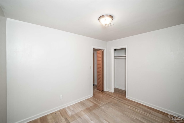 unfurnished bedroom with a closet and light hardwood / wood-style flooring