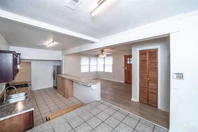 kitchen featuring stainless steel refrigerator, ceiling fan, sink, and light hardwood / wood-style floors