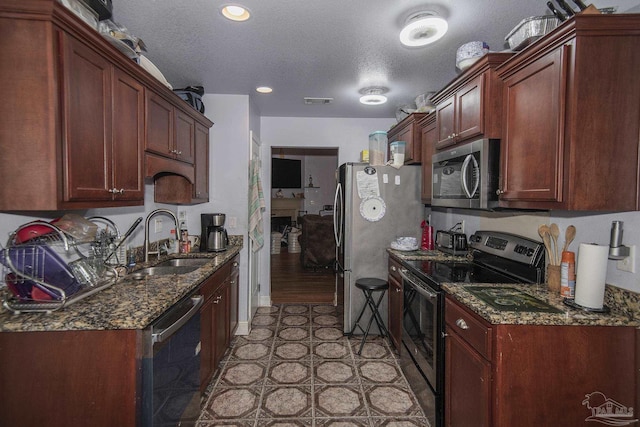 5800 Providence Loop, Pensacola, FL 32526 - kitchen with stainless steel appliances, a sink, dark stone counters, a textured ceiling, and recessed lighting
